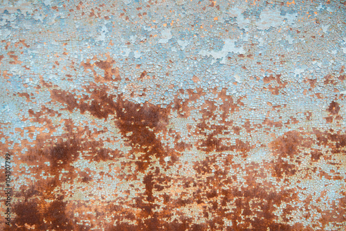 Old rusty metal wall with blue peeling paint
