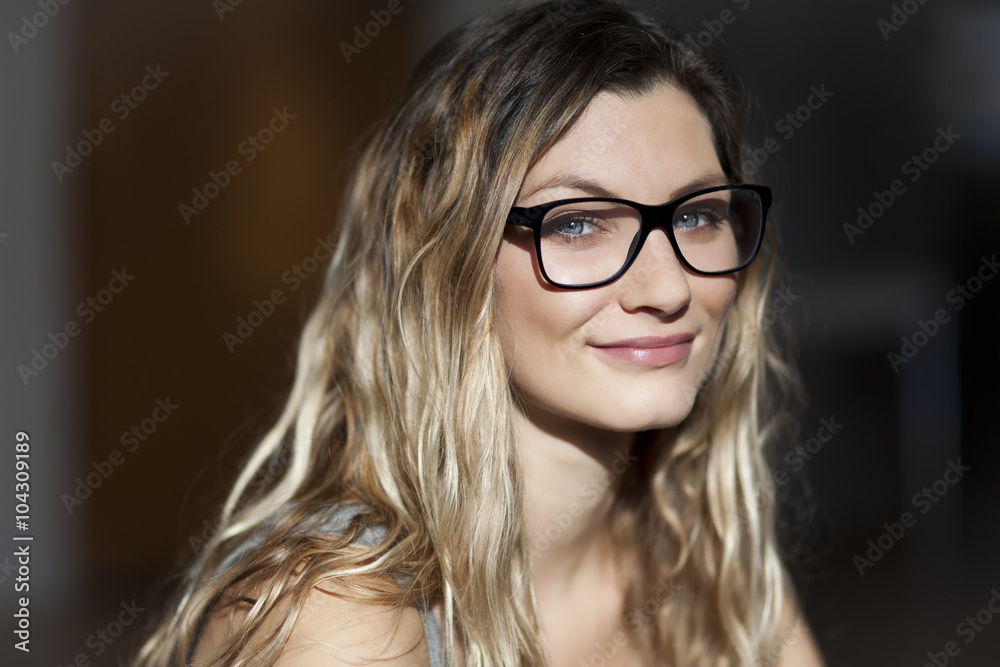 Pretty woman with glasses smiling At the camera