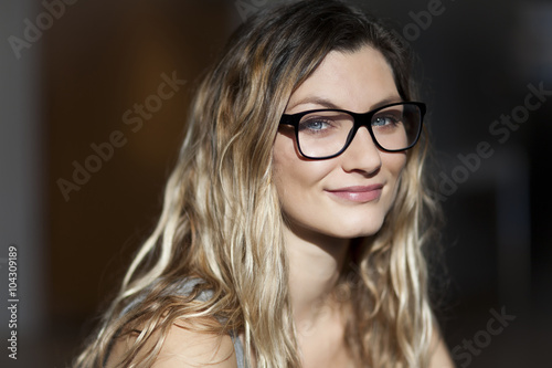 Pretty woman with glasses smiling At the camera