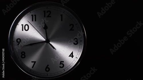 Time-lapse of a clock face with hands going up to 12 o'clock and beyond photo