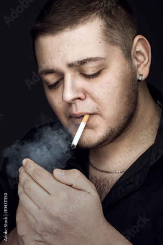 Portrait of man smoking cigarette in black shirt