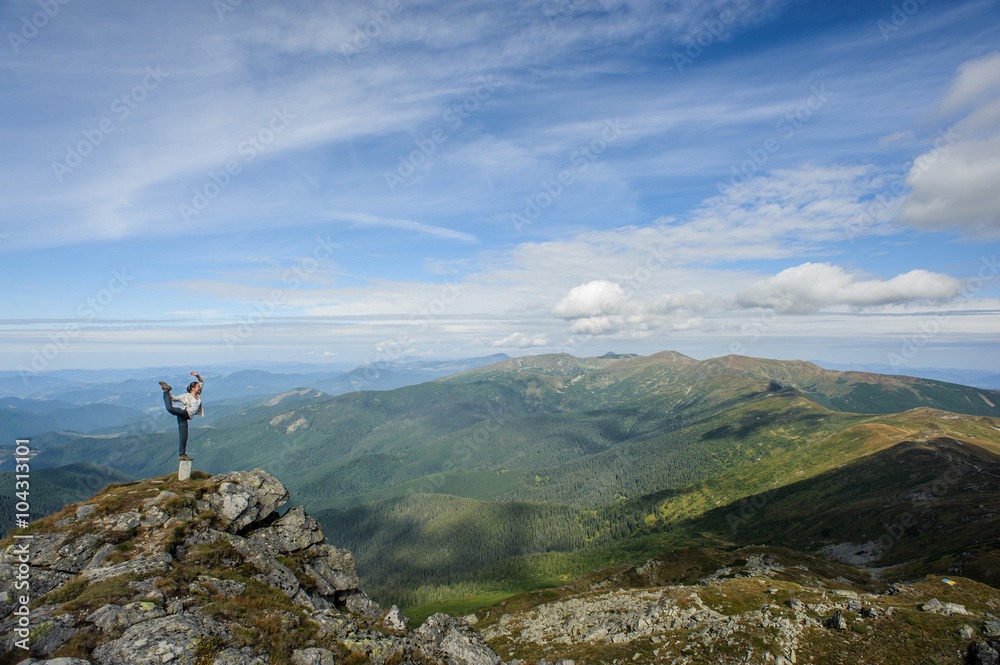 young woman practices yoga on a mountain top, Carpathian mountains