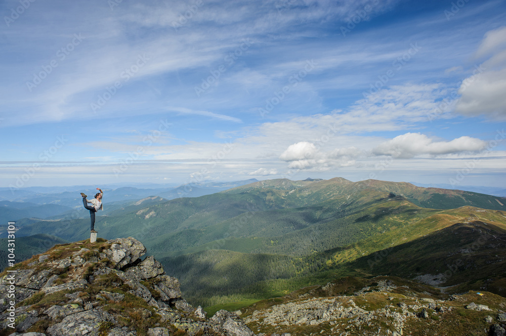 Obraz premium young woman practices yoga on a mountain top, Carpathian mountains