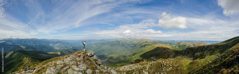 young girl practices yoga on a mountain top in the mountains