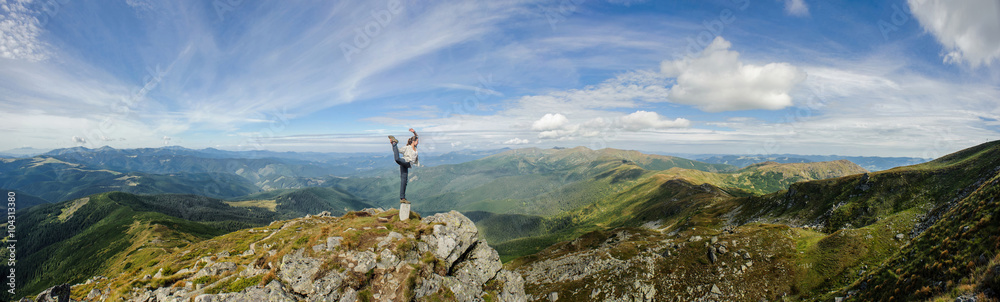 Young woman practices yoga on a mountain top, Carpathian mountains