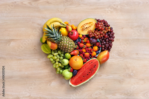Fototapeta Naklejka Na Ścianę i Meble -  Heart symbol. Fruits diet concept. Healthy eating concept / food photography of heart made from different fruits on wooden table
