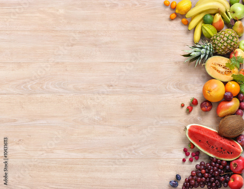 Fototapeta Naklejka Na Ścianę i Meble -  Healthy fruits background / studio photo of different fruits on wooden table, top view. High resolution product.