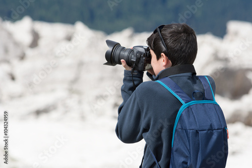 Ragazzino che fotografa con una reflex digitale