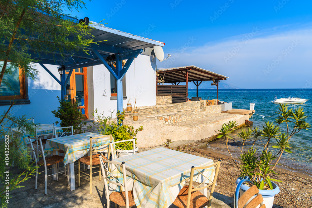 Typical Greek tavern in small fishing village on coast of Samos island, Greece
