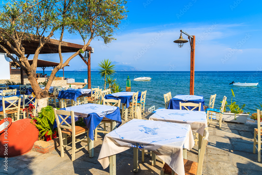 Typical Greek tavern in small fishing village on coast of Samos island, Greece