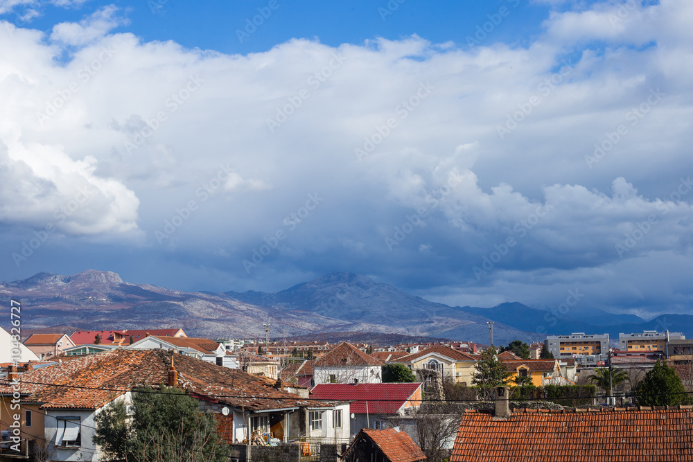 Roofs of Podgorica, Montenegro, mountains and evening sky with clouds