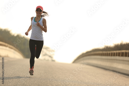 young fitness woman trail runner running  on city road photo