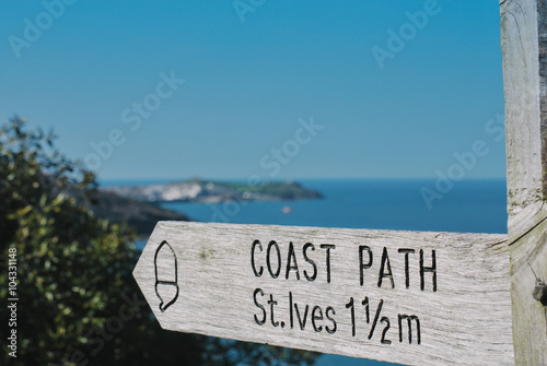 Coastal path sign to St Ives with St Ives in the distance