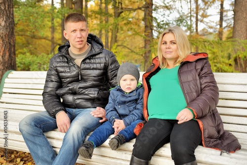 Family sits in autumn park on bench © dojo666