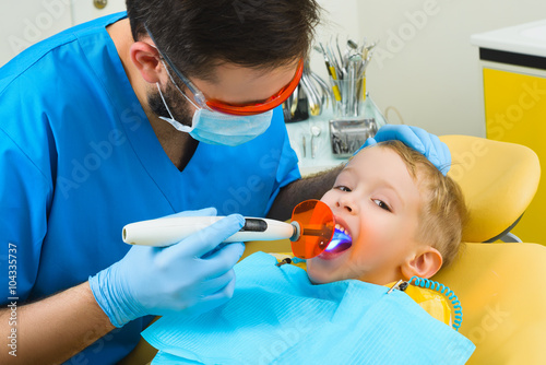 Dentist treats teeth of patient in dental clinic