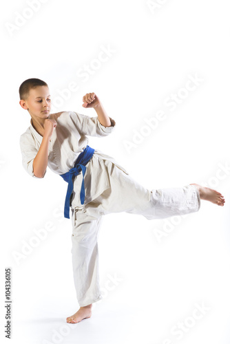 boy in kimono during training karate exercises on white background