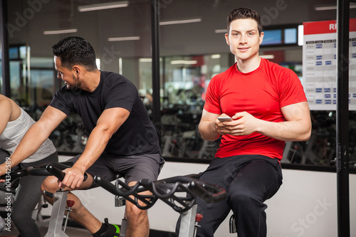 Young man using a smartphone at the gym