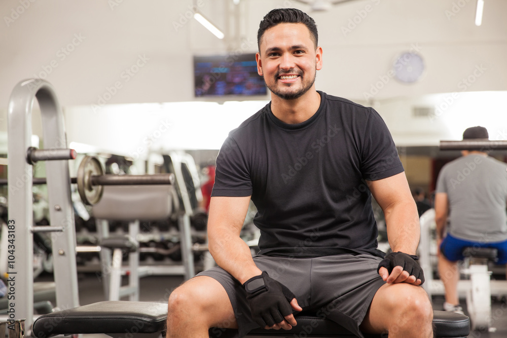 Young man sitting on a bench at the gym Young man sitting on a bench at the gym