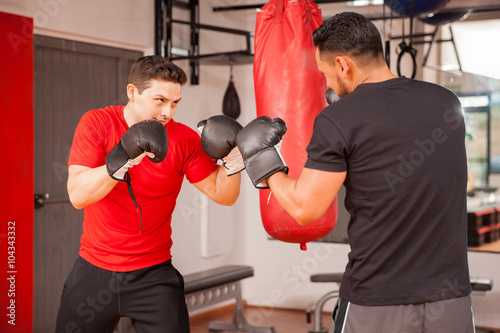 Young men sparring in boxing room photo