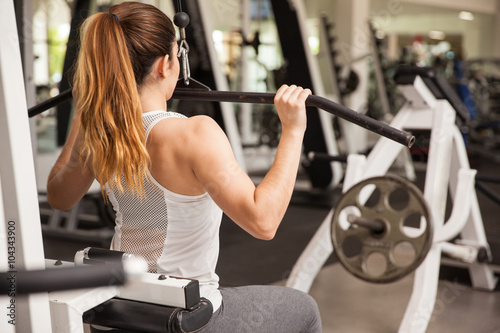 Strong woman on a lat pulldown machine