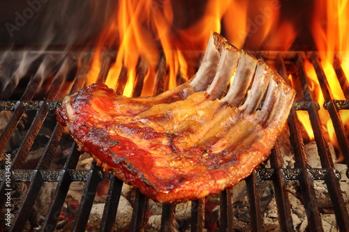 Baby Back Or Spare Ribs On The Flaming BBQ Grill photo