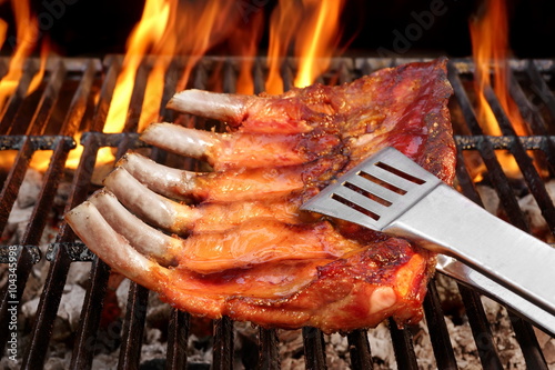 Baby Back Or Spare Ribs On The Flaming BBQ Grill photo