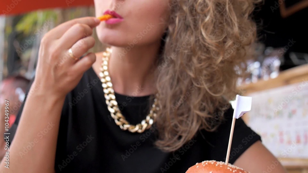 Young Female Eating Vegetarian French Fries and Burger in Cafe Young Female Eating Vegetarian French Fries and Burger in Cafe