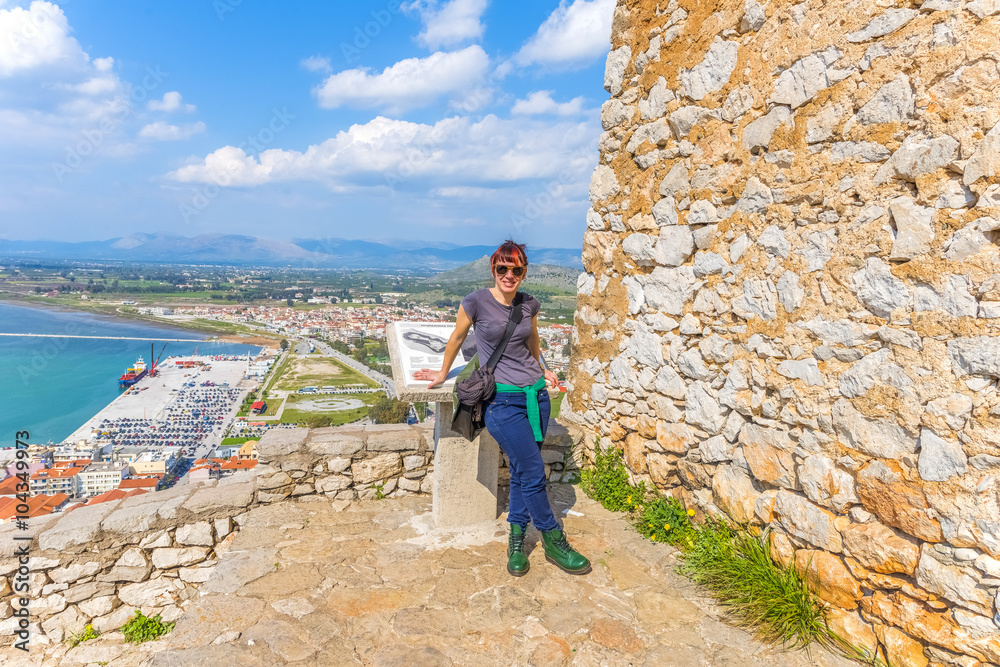 Girl standing on top of the old town of Nafplio, Greece, in fron