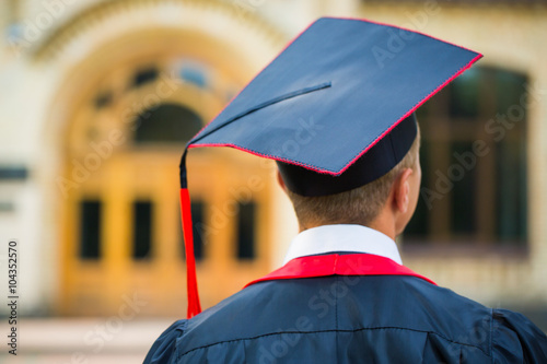 graduate student hands holding diploma from the back