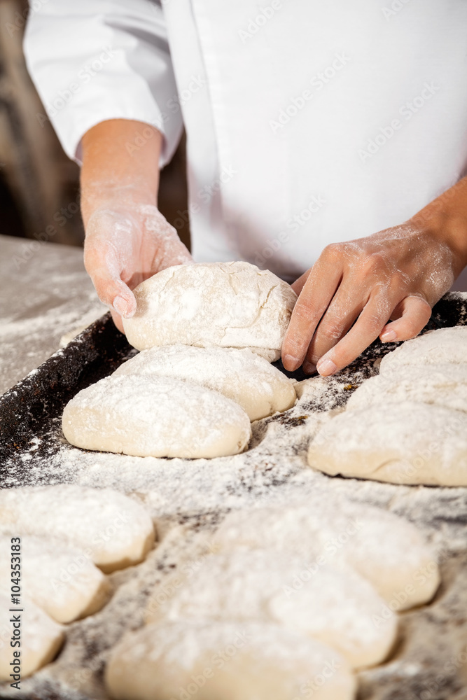 Midsection Of Woman Keeping Bread Dough In Baking Tray Midsection Of Woman Keeping Bread Dough In Baking Tray