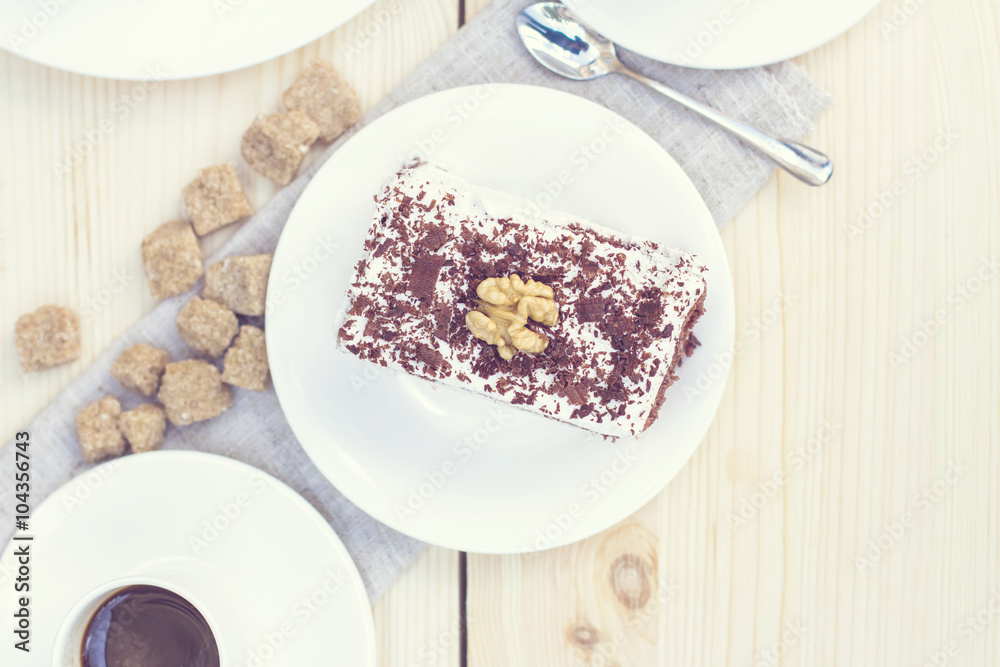 Delicious chocolate cake on plate on table on light background. Tonned photo. Delicious chocolate cake on plate on table on light background. Tonned photo.