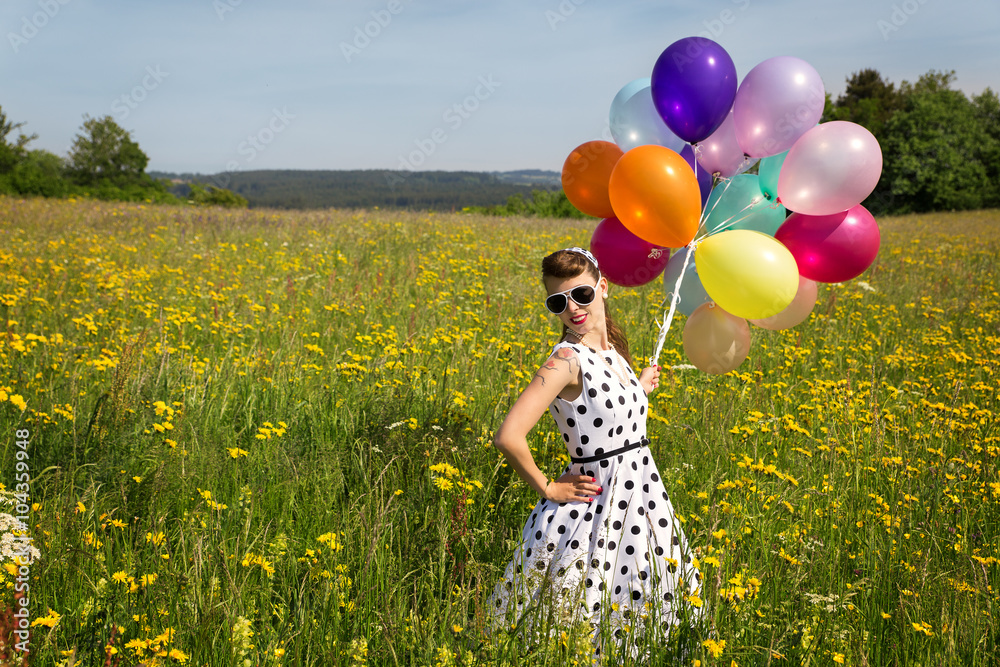 Hübsche Frau im Retro Kleid und Luftballons auf einer Wiese Stock-Foto |  Adobe Stock