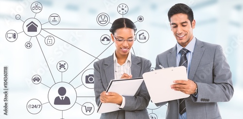 Composite image of smiling business people writing on clipboards