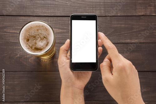 Using smartphone beside of beer in the pub