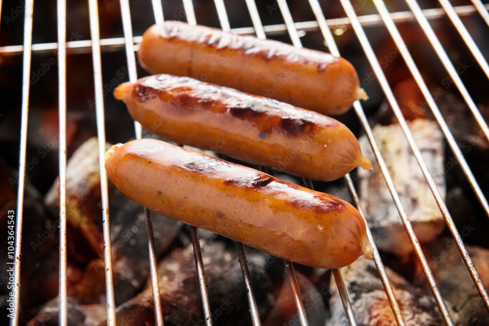 Grilling sausages over flames on the grill Grilling sausages over flames on the grill