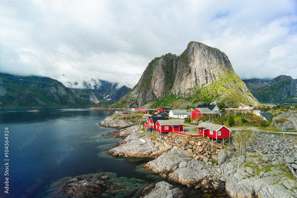 Amazing view of Reine - fishing village with red houses near fjord and green mountains. Beauty of Hamnoya, Lofoten islands, Norway