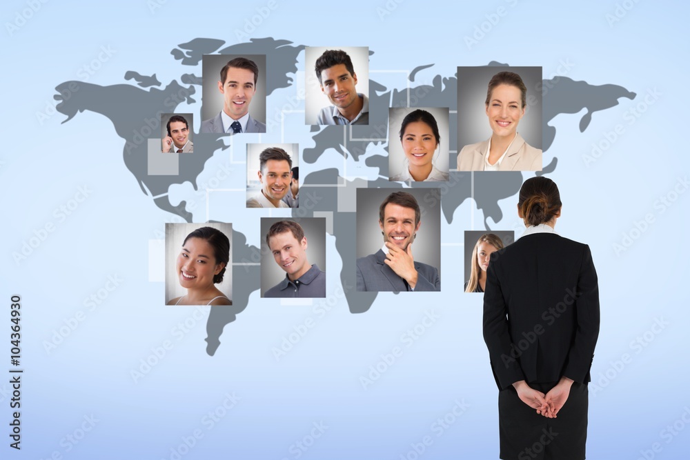 Obraz premium Composite image of young businesswoman standing with hands behind back