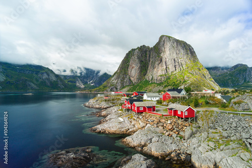 Amazing view of Reine - fishing village with red houses near fjord and green mountains. Beauty of Hamnoya, Lofoten islands, Norway