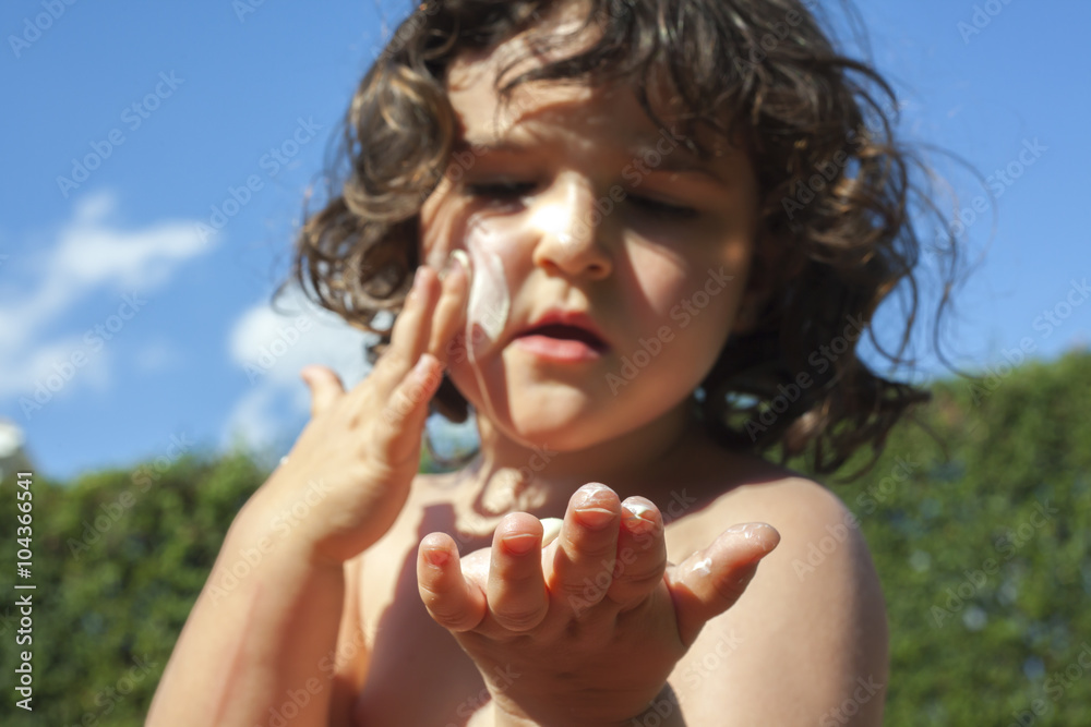 Girl applying lotion.