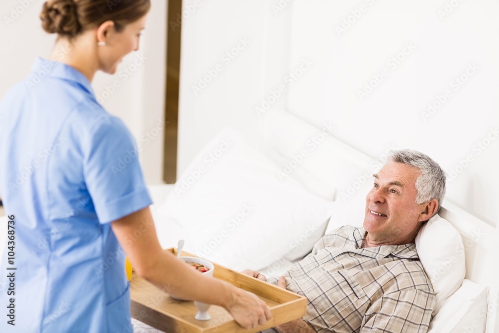 Fototapeta premium Nurse taking care of suffering senior patient 
