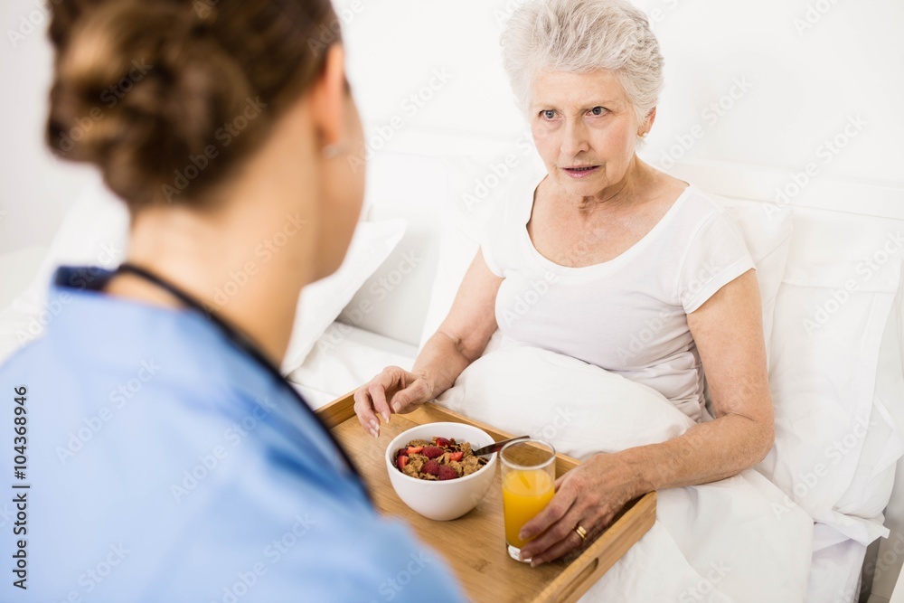 Nurse taking care of suffering senior patient 