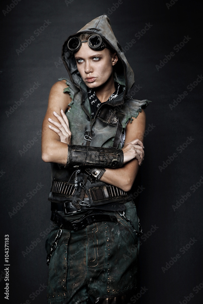 Young woman in brutal style clothes with goggles on studio black background Young woman in brutal style clothes with goggles on studio black background