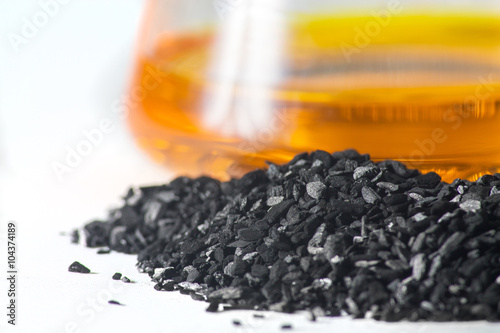 loose coal on the background of glass test tubes with colored li