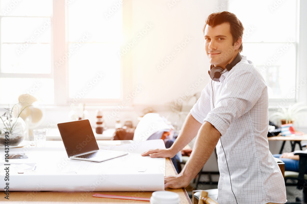 Young man standing in creative office Young man standing in creative office