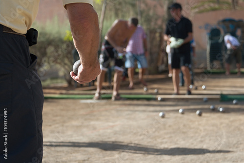 Senior playing petanque, balls on the ground