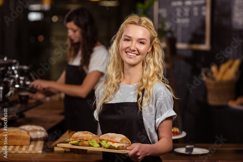 Pretty waitress holding a tray with sandwiches 