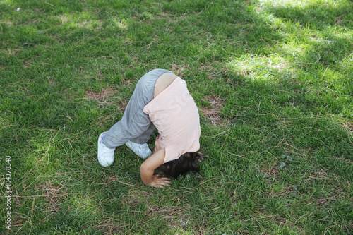 Girl doing somersault on lawn