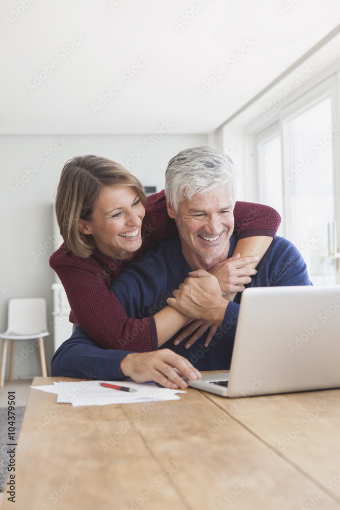 Happy couple using laptop at home Happy couple using laptop at home