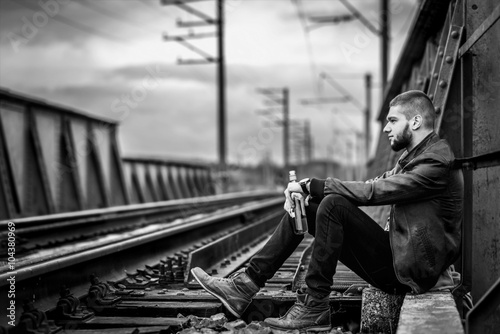 Man with beard sitting on the railway