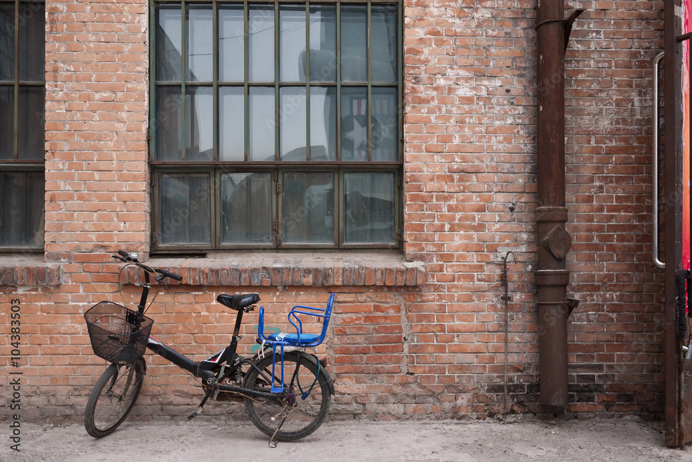 Old bicycle and the old red brick buiding background